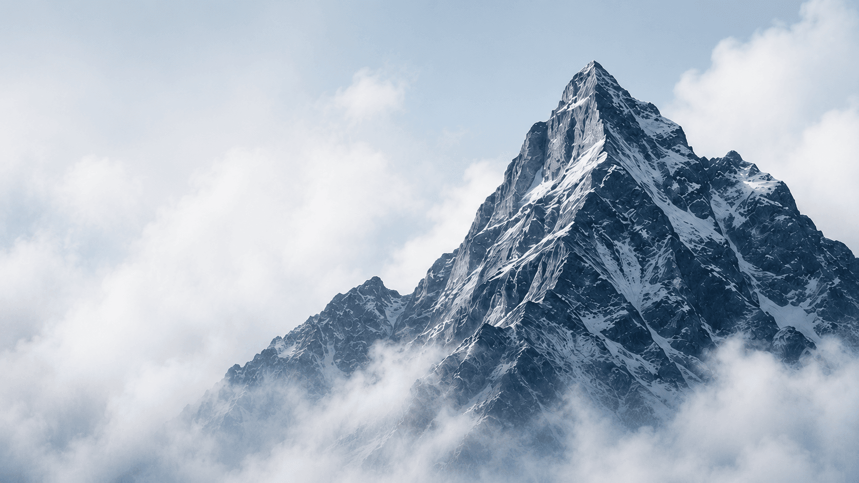 A snow-covered mountain rising above clouds